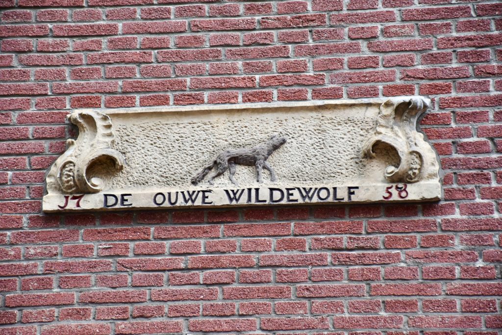 Brick wall with a stone plaque, carved with a wolf design for Wolf Street