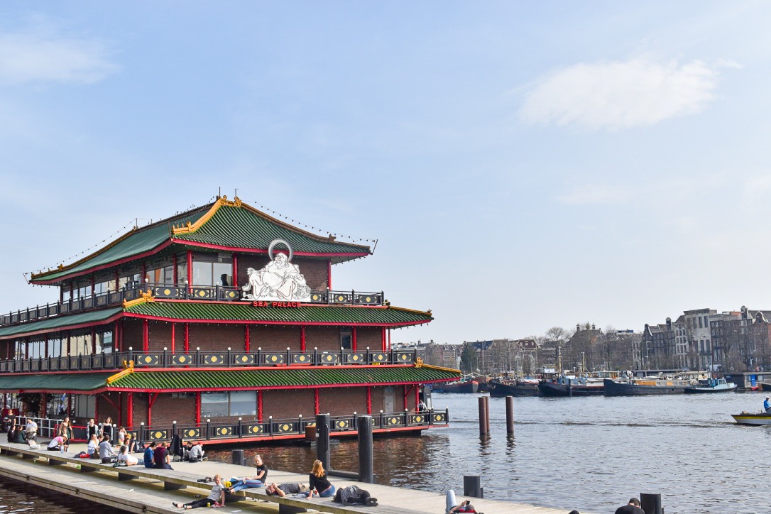 Large green and red restaurant in Chinese style floating on canal in Amsterdam